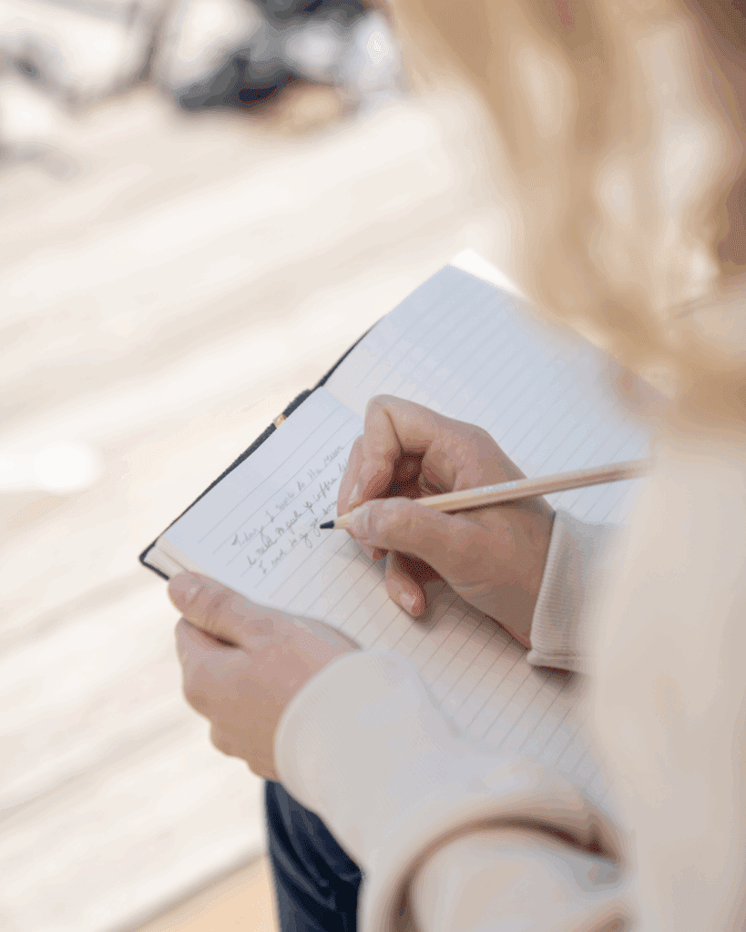 Woman starting her daily wellness habits with a gratitude journal and mindful reflection