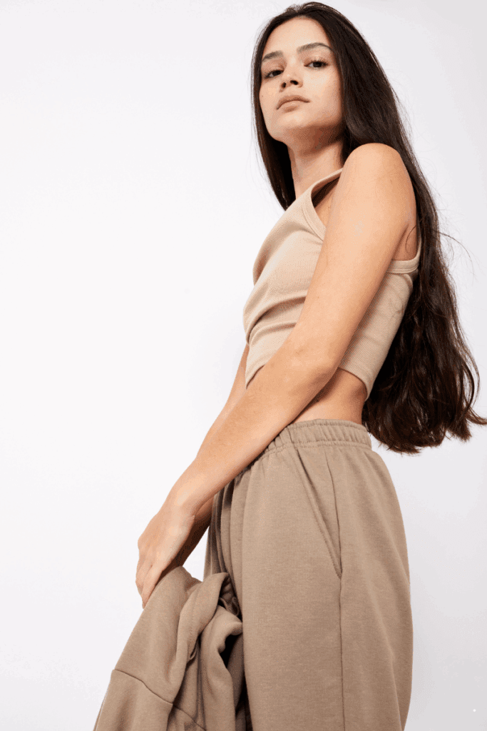 Comfortable yet chic summer airport outfit featuring high-waisted pants, a fitted tank, and a light cardigan ideal for travel days.