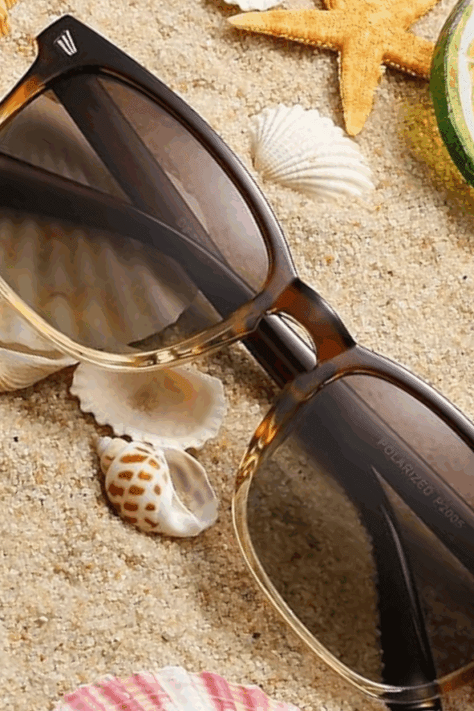 Chic sunglasses laid on a neutral background, stylish airport accessory for summer travel.