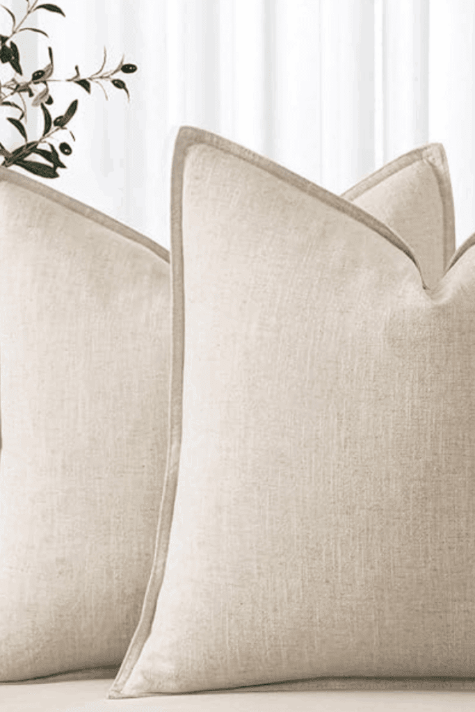 Neutral beige linen pillow covers on a modern sofa with cozy throw blanket – minimal boho home decor under $25.