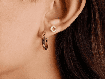 A close up image of a women's face showing the small gold hoop in her ear.